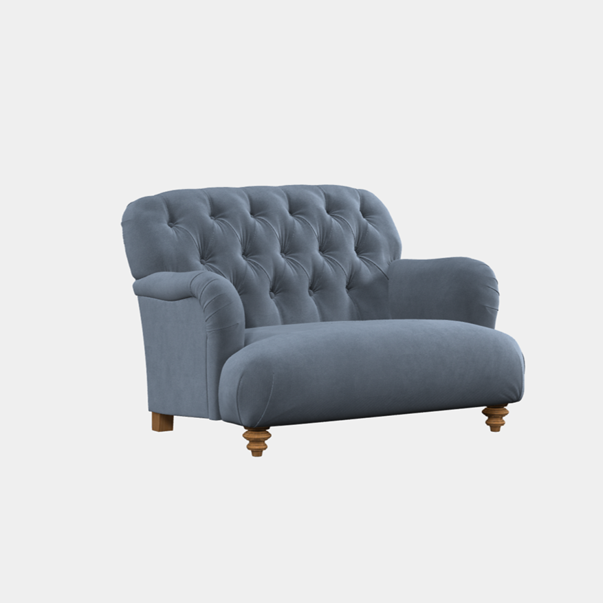 A blue upholstered sofa with a deep buttoned back and wooden legs.