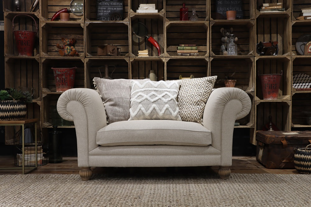 Beige armchair with patterned cushions in a room with wooden crate shelves.