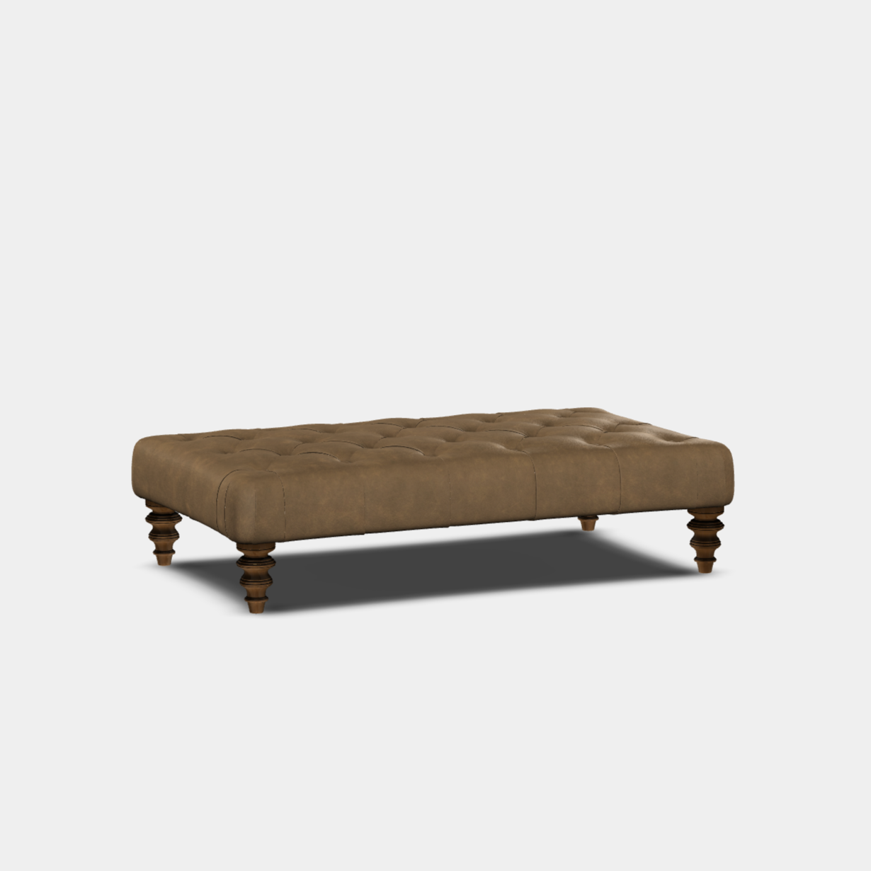 A brown, buttoned footstool with curved sides and wooden legs, set against a white background.