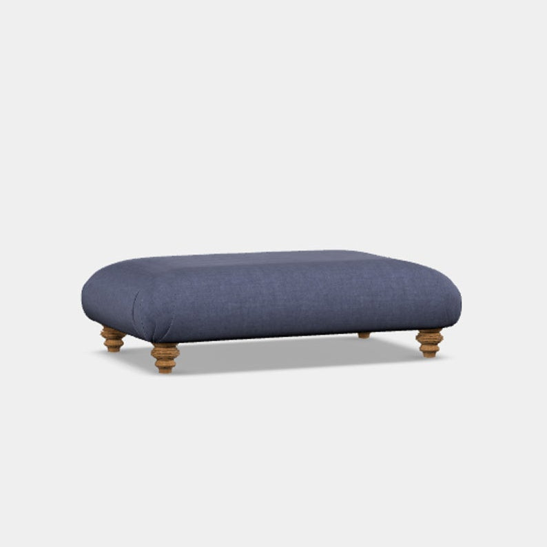 A navy blue upholstered footstool with a domed top and turned wooden legs.