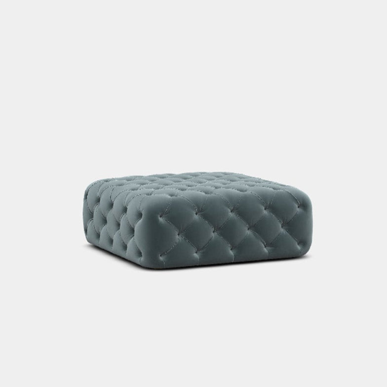 A gray upholstered footstool with deep button detailing, presented against a white background.