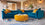 Blue sofa with yellow cushions in a modern living room with brick walls.