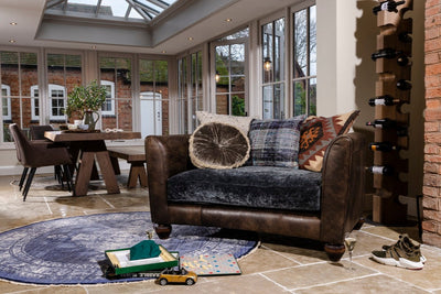 Living room with brown leather sofa, dining table, and wine rack.