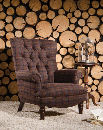 Plaid armchair in front of a wooden log wall
